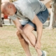 Runner outdoors holding ankle in pain after training injury
